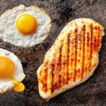Fried eggs and chicken breast cooking.