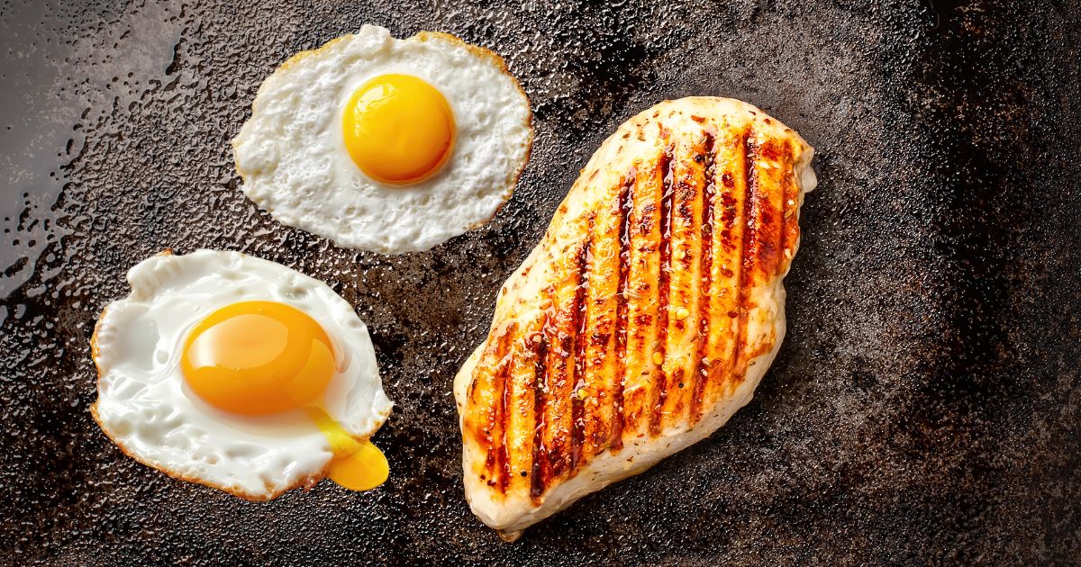 Fried eggs and chicken breast cooking.