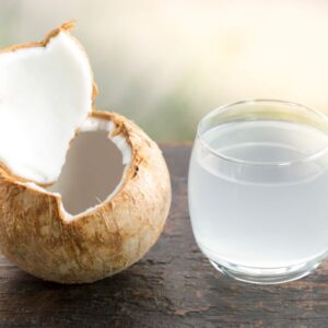 Coconut Water and a coconut on a table.