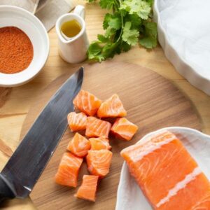 Raw salmon on cutting board.