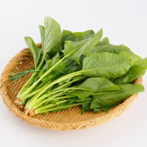 Spinach in a brown wicker bowl.