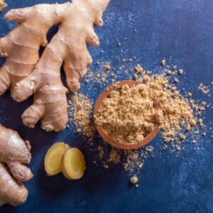 Ginger root and ground ginger on blue background.
